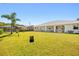 Expansive backyard with a lush lawn, mature palm trees, and a view of the rear of the home at 25730 Deep Creek Blvd, Punta Gorda, FL 33983