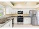 Bright kitchen with stainless steel appliances, granite countertops, and ample white cabinetry at 25730 Deep Creek Blvd, Punta Gorda, FL 33983