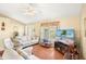 Inviting living room with wood floors, a ceiling fan, comfortable seating, and a view of the outdoors at 25730 Deep Creek Blvd, Punta Gorda, FL 33983