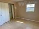 A bedroom featuring a closet, window, and tile flooring at 30147 Holly Rd, Punta Gorda, FL 33982