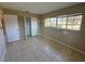 A bedroom with tiled floor, closet and bright window, offering functional space and natural light at 30147 Holly Rd, Punta Gorda, FL 33982