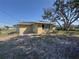 View of the home's exterior and large yard with mature trees at 30147 Holly Rd, Punta Gorda, FL 33982