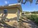 Side view of home with yellow stucco and small windows, partially fenced in yard at 30147 Holly Rd, Punta Gorda, FL 33982