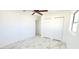 This bedroom has white walls, marble look floors, a ceiling fan and a double-door closet at 3372 Elkcam Blvd, Port Charlotte, FL 33952