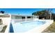 Backyard swimming pool with a white fence, surrounded by lush greenery under a clear blue sky at 3372 Elkcam Blvd, Port Charlotte, FL 33952