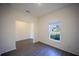 This bedroom offers a window with natural lighting, gray wood floors and light colored walls at 359 Paramaribo St, Punta Gorda, FL 33983