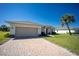 Charming single-story home featuring a brick driveway, two-car garage, and lush lawn at 359 Paramaribo St, Punta Gorda, FL 33983