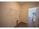 Neutral laundry room with open doorway to kitchen, overhead rack and hookups at 359 Paramaribo St, Punta Gorda, FL 33983