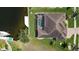 Aerial view of a home with a screened pool, dock, and well-manicured lawn near the water at 3606 Whippoorwill Blvd, Punta Gorda, FL 33950