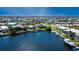 Aerial view showcasing a waterfront community with homes, canals, and boat docks under a clear blue sky at 3606 Whippoorwill Blvd, Punta Gorda, FL 33950