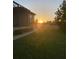 Backyard at sunset with a lush lawn and a hint of the home's screened patio at 3606 Whippoorwill Blvd, Punta Gorda, FL 33950