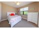 Bright bedroom with a floral patterned bed, white dresser, and large window for natural light at 3606 Whippoorwill Blvd, Punta Gorda, FL 33950