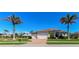 Inviting home with a well-manicured lawn and lush landscaping with palm trees and a brick driveway at 3606 Whippoorwill Blvd, Punta Gorda, FL 33950