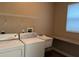 Functional laundry room includes washer, dryer, utility sink, and folding countertop at 3606 Whippoorwill Blvd, Punta Gorda, FL 33950