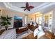 Spacious living room with a decorative ceiling fan, fireplace, and comfortable seating with views to the foyer at 3606 Whippoorwill Blvd, Punta Gorda, FL 33950