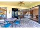 An outdoor patio area with a ceiling fan, a decorative table, and a view into an open concept kitchen and dining area at 3606 Whippoorwill Blvd, Punta Gorda, FL 33950