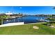Beautiful waterfront view with a boat dock, lush green lawn, and serene canal in a sunny neighborhood at 3606 Whippoorwill Blvd, Punta Gorda, FL 33950