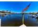 Picturesque waterfront view with boats docked, an American flag, and calm canal waters at 3606 Whippoorwill Blvd, Punta Gorda, FL 33950