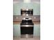 View of the stainless steel microwave and oven among the light green cabinets at 594 W Tarpon Nw Blvd, Port Charlotte, FL 33952