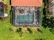 Overhead aerial view of a screened pool in a yard with green grass and landscaping at 10357 Crooked Creek Dr, Venice, FL 34293