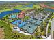 Aerial showcasing tennis courts, pool, clubhouse, landscaping, and surrounding community with ponds and golf course at 10357 Crooked Creek Dr, Venice, FL 34293
