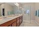 Luxurious bathroom highlighting double sinks, granite countertop, and a modern glass-enclosed shower with tiled accents at 10357 Crooked Creek Dr, Venice, FL 34293