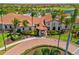 Beautiful clubhouse featuring a terracotta roof, lush landscaping, and a convenient bike rack at 10357 Crooked Creek Dr, Venice, FL 34293