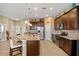 Spacious kitchen with stainless steel appliances, granite countertops, central island, and dark wood cabinets at 10357 Crooked Creek Dr, Venice, FL 34293