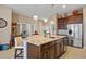 Bright kitchen island with granite countertop, dark wood cabinetry, stainless steel sink and seating at 10357 Crooked Creek Dr, Venice, FL 34293