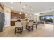 Bright open kitchen with stainless steel appliances, a granite island with seating, and views of the living room at 10357 Crooked Creek Dr, Venice, FL 34293