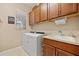 Functional laundry room with a sink, cabinets for storage, and modern appliances, enhancing convenience at 10357 Crooked Creek Dr, Venice, FL 34293