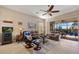 Cozy living room featuring comfortable leather seating, ceiling fan, tile flooring, and sliding glass doors to the outdoor area at 10357 Crooked Creek Dr, Venice, FL 34293