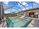 Spacious pool area with lounge chairs, ceiling fans and lovely screened-in enclosure at 10357 Crooked Creek Dr, Venice, FL 34293
