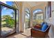Inviting porch with comfortable wicker chairs and view of tropical landscaping at 10357 Crooked Creek Dr, Venice, FL 34293
