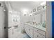 Bright white bathroom with double vanity, tile floors, and stylish fixtures at 1212 Benjamin Franklin Dr # 102, Sarasota, FL 34236