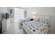 Bright bedroom with two twin beds, adorned with starfish-patterned bedding, and light neutral walls and tile floor at 1212 Benjamin Franklin Dr # 102, Sarasota, FL 34236
