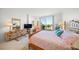 Bright main bedroom with a king bed, dresser, and balcony access with beach views at 1212 Benjamin Franklin Dr # 102, Sarasota, FL 34236