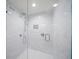 Modern bathroom featuring a glass-enclosed shower with white marble walls, a built-in niche, and sleek fixtures at 1212 Benjamin Franklin Dr # 102, Sarasota, FL 34236