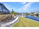 Backyard featuring a landscaped walkway leading to a private dock and canal at 122 Colonial Se St, Port Charlotte, FL 33952