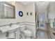 Bright bathroom with white tiled walls, mosaic accents, and pedestal sink at 122 Colonial Se St, Port Charlotte, FL 33952