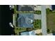 Aerial view of a modern home with a screened lanai, lush landscaping, and waterfront access at 1230 Royal Tern Dr, Punta Gorda, FL 33950