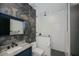 Modern bathroom featuring patterned accent wall and a glass-enclosed shower at 1230 Royal Tern Dr, Punta Gorda, FL 33950
