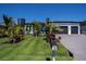 Beautiful home with dark gray roof, black two-car garage and luxurious landscaping at 1230 Royal Tern Dr, Punta Gorda, FL 33950