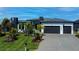 Modern home with a well-manicured lawn, a large driveway, and a two-car garage on a sunny day at 1230 Royal Tern Dr, Punta Gorda, FL 33950