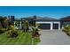 Contemporary home featuring manicured landscaping, a paver driveway, and a two-car garage at 1230 Royal Tern Dr, Punta Gorda, FL 33950