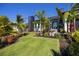 Contemporary home showcasing a lush green lawn and tropical landscaping with vibrant palm trees at 1230 Royal Tern Dr, Punta Gorda, FL 33950