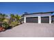 Modern home features a wide driveway leading to a two-car garage, complemented by vibrant landscaping at 1230 Royal Tern Dr, Punta Gorda, FL 33950