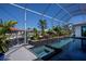 Gorgeous in-ground pool featuring a tiled waterfall and spa in a screened lanai at 1230 Royal Tern Dr, Punta Gorda, FL 33950