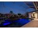 Stunning in-ground pool with an integrated spa and colorful LED lighting at night at 1230 Royal Tern Dr, Punta Gorda, FL 33950