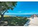 Picturesque waterfront view with lush grassy area, benches, and a pier under a clear blue sky at 1230 Royal Tern Dr, Punta Gorda, FL 33950